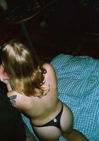 Молодая девушка с тату на животе без одежды валяется на постели 4 фото
