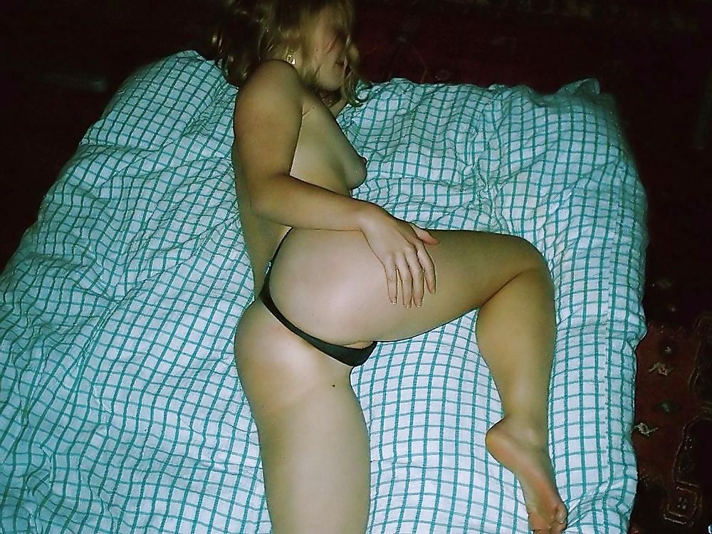 Молодая девушка с тату на животе без одежды валяется на постели 11 фотография