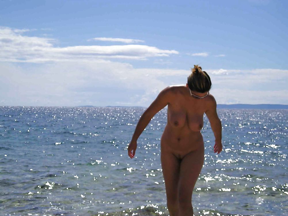 Большегрудая чика с интимной стрижкой отдыхает на берегу моря 14 фотография