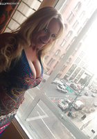 Пошлая блонда хочет показать огромные сиськи возле окна 6 фото