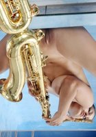 Голая музыкантка красуется большими дойками рядом с саксофоном 4 фото