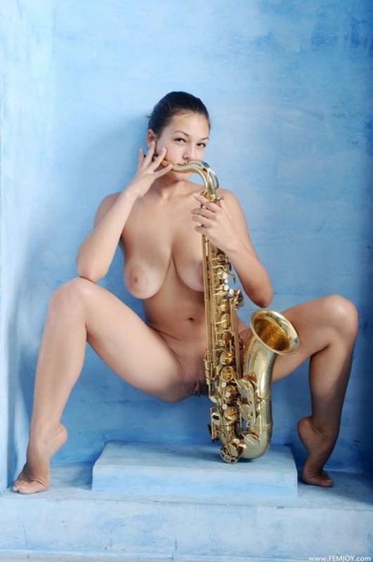 Голая музыкантка красуется большими дойками рядом с саксофоном 2 фотография
