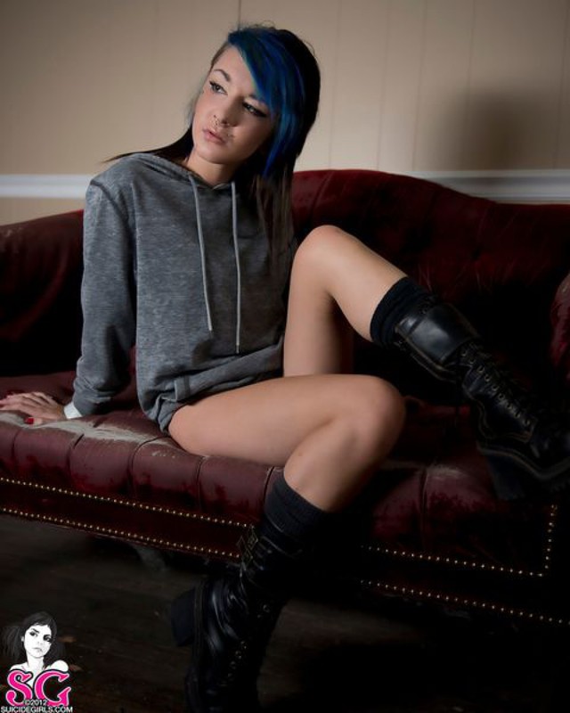 Молодая неформалка с синими волосами позирует на диване 1 фотография