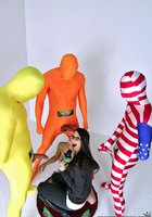 Ведущая смотрит как участница телешоу ублажает трех мужчин в цветных костюмах 10 фото