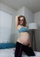 Беременная молодуха с пигментными пятнами позирует на постели в розовых трусах 3 фото
