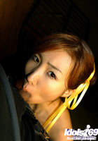 Азиатка с желтыми ленточками в волосах сосет писюн стоя на коленях 5 фото
