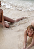 Несколько лесбиянок отдыхают голышом на песчаном пляже у моря 6 фото