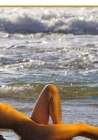 Длинноволосая брюнетка позирует голышом на морском берегу 9 фото