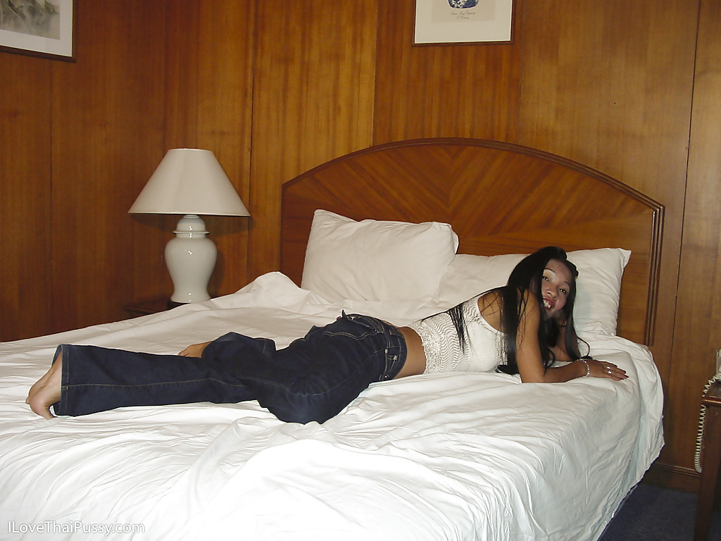 Смуглая тайка раздевается догола на двуспальной кровати в отеле 3 фотография