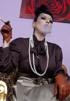 Курящая мамка в кожаных перчатках позирует на леопардовом кресле 7 фото
