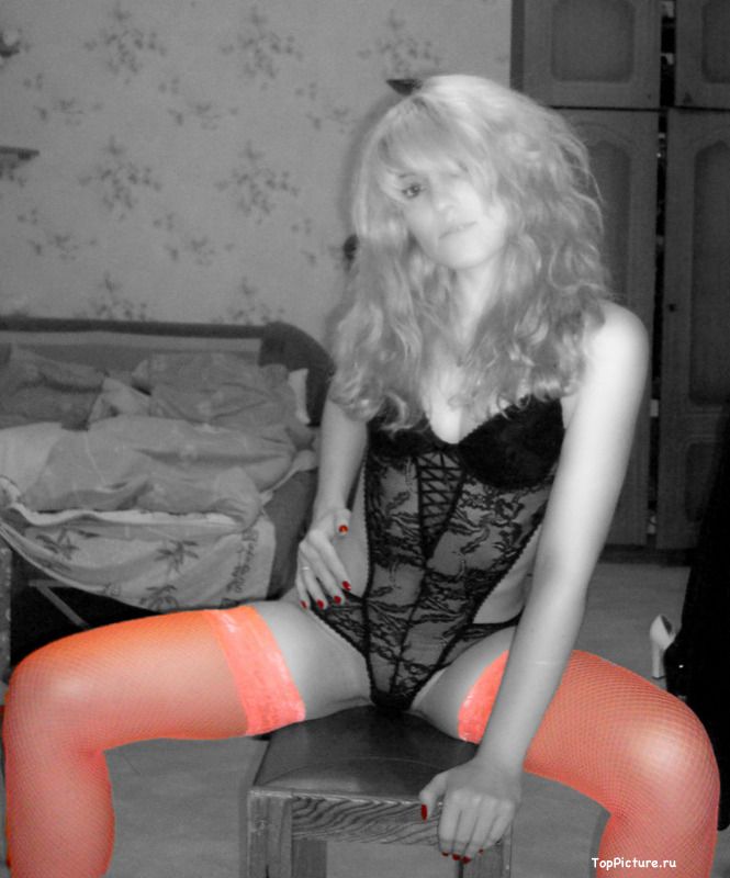Стройная блондинка в оранжевых чулках позирует в спальне 7 фотография